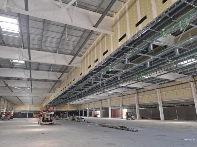 Interior del Pabellón de Congresos de Dos Hermanas, Sevilla, durante los trabajos de instalación eléctrica de baja tensión con canalizaciones y equipos en montaje.
